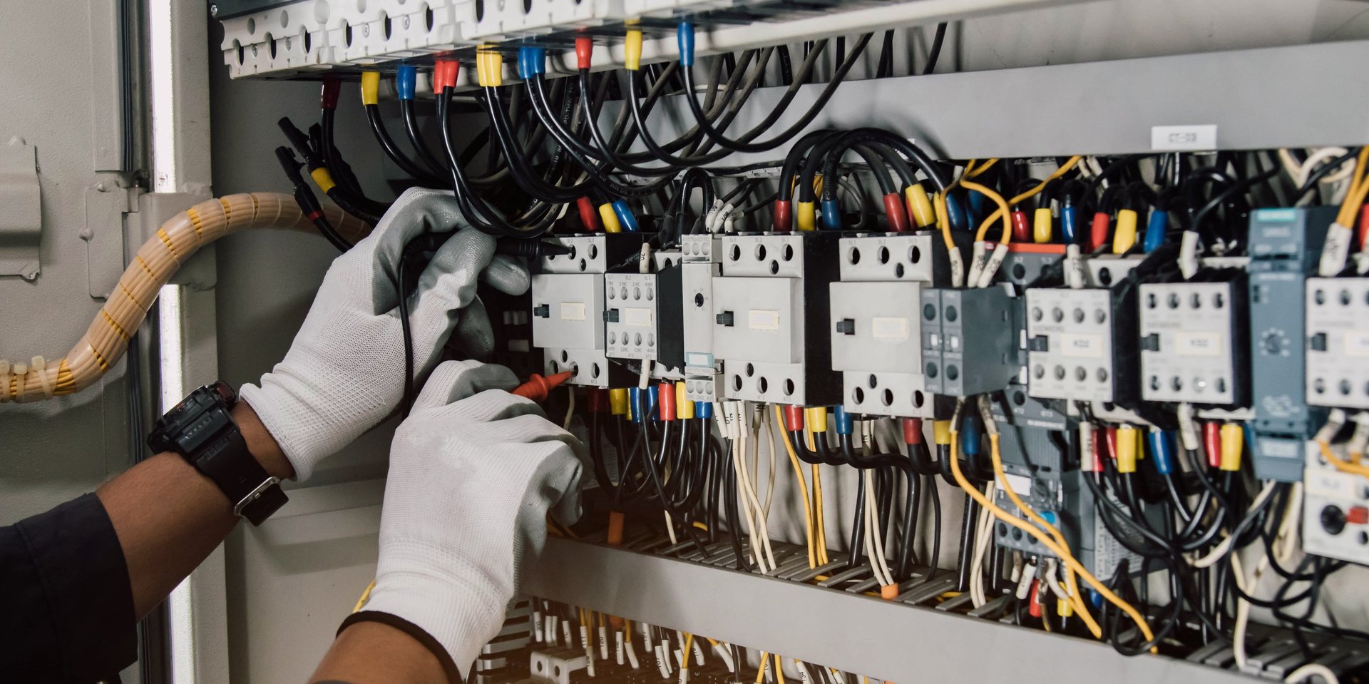 Electrician engineer tests electrical installations and wires on relay protection system.